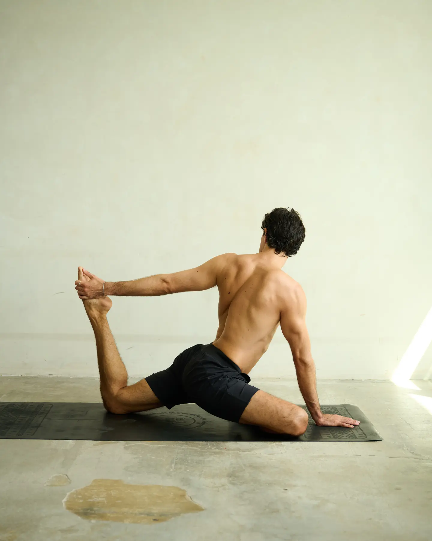 Ruben in a seated hip and hamstring stretch on the mat